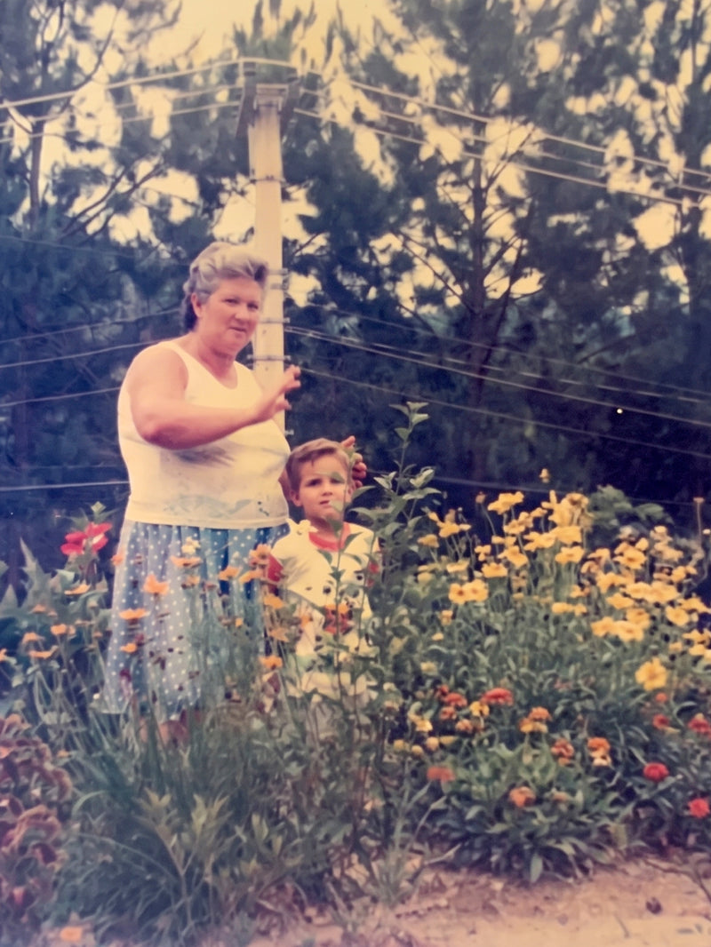 The founder's grandmother and him as a child in her flower garden in the Brazilian countryside